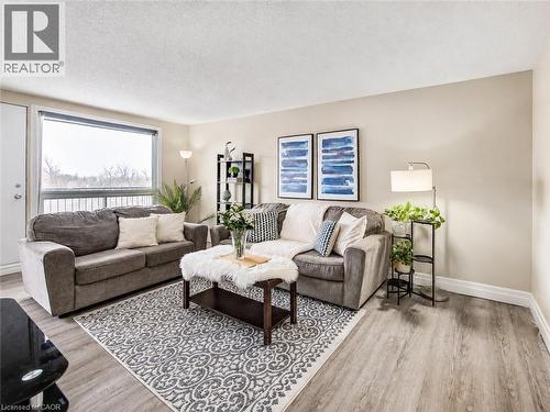 Spacious room with wood-finish flooring, a large window, neutral wall tones, and white trim - 4 Avalon Place Unit# 303, Kitchener, ON 