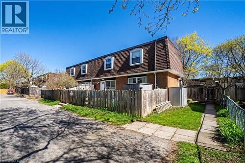 Brick exterior with a gambrel roofline featuring multiple dormer windows - 648-654 Francis Road, Burlington, ON 