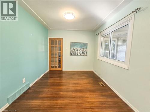 Hardwood-finish flooring, white window trim, wood-frame door with glass panels, and a flush-mount ceiling light fixture - 11 Duncairn Avenue, Kitchener, ON 