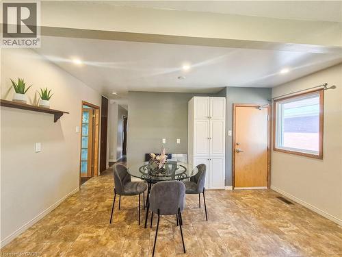 Recessed lighting illuminates the open-concept space featuring a built-in white cabinet unit and wood-finish flooring throughout - 11 Duncairn Avenue, Kitchener, ON 