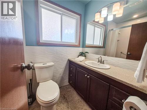Vanity with integrated sink, dark wood-finish cabinetry, and brushed nickel fixtures - 11 Duncairn Avenue, Kitchener, ON 