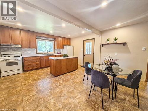 Kitchen featuring wood cabinetry, a center island with countertop, an undermount sink, and a tiled backsplash - 11 Duncairn Avenue, Kitchener, ON 