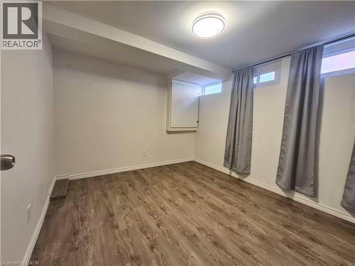 Wood-finish flooring, white baseboards, and ceiling-mounted light fixture - 11 Duncairn Avenue, Kitchener, ON 