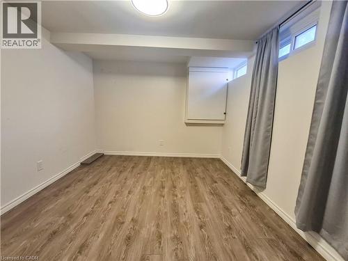 Wood-finish flooring, white walls, and an overhead flush-mount light fixture - 11 Duncairn Avenue, Kitchener, ON 