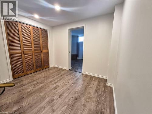 Wood-finish flooring, recessed ceiling lighting, louvered bi-fold closet doors, and white painted walls - 11 Duncairn Avenue, Kitchener, ON 