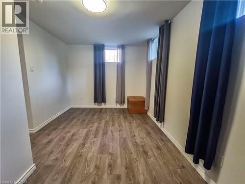Wood-finish flooring with white baseboards, recessed window, and flush-mount ceiling light - 11 Duncairn Avenue, Kitchener, ON 