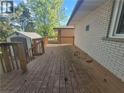 Expansive wood deck with wood railings, a storage shed, and a brick exterior wall - 11 Duncairn Avenue, Kitchener, ON 