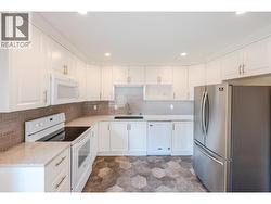 Kitchen with quartz countertops & tile backsplash - 