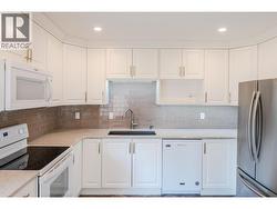 Kitchen with quartz countertops & tile backsplash - 