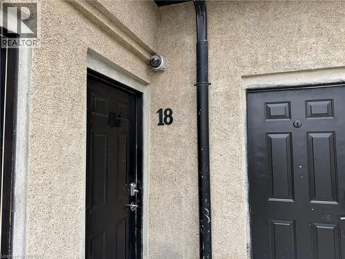 Cream-colored stucco exterior with black paneled doors - 12 Bridgeport Road E Unit# 18, Waterloo, ON 