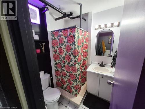 Tiled shower stall with pipe-style enclosure, vanity with basin sink, and built-in shelving - 12 Bridgeport Road E Unit# 18, Waterloo, ON 
