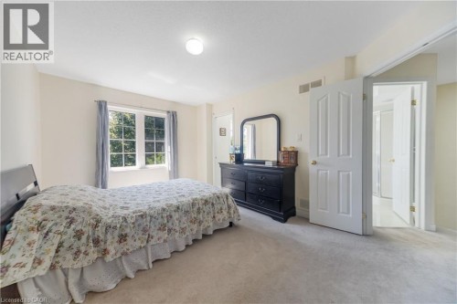 Carpeted flooring, white trim, paneled interior doors, and a multi-pane window - 82 Milner Downs Crescent, Ottawa, ON 