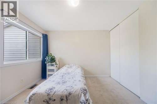Bright room featuring a large window, neutral carpeting, and a built-in closet with sliding doors - 82 Milner Downs Crescent, Ottawa, ON 
