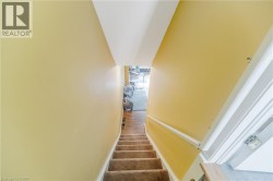 Carpeted staircase with a white handrail and yellow walls - 
