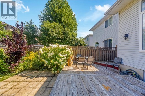 Expansive backyard featuring a wood deck, stone patio, and mature landscaping - 82 Milner Downs Crescent, Ottawa, ON 