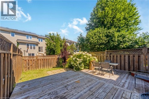 Expansive wood-finish deck with a stone paver patio area, surrounded by a wood fence with lattice accents - 82 Milner Downs Crescent, Ottawa, ON 