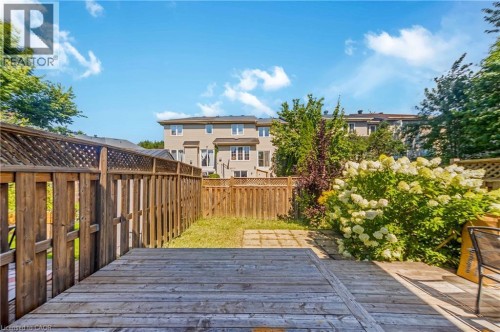 Expansive backyard featuring a wood deck, wood fencing, and mature landscaping - 82 Milner Downs Crescent, Ottawa, ON 