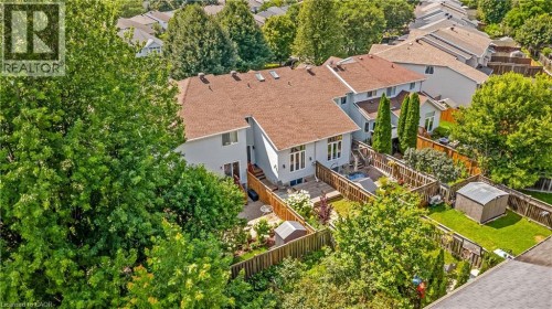 Fenced backyard with a privacy fence, manicured lawn, and mature trees - 82 Milner Downs Crescent, Ottawa, ON 