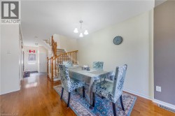 Hardwood flooring, painted walls, a built-in staircase with wood railings, and an overhead light fixture - 