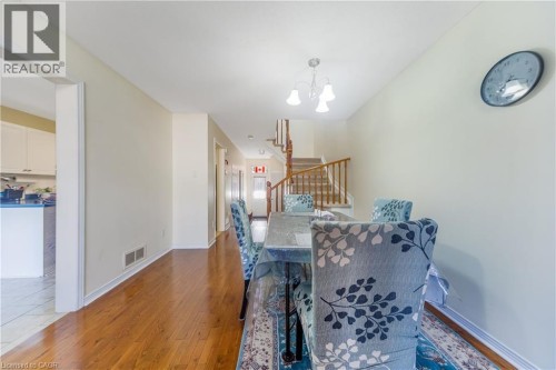 Hardwood flooring throughout, a three-light chandelier, and a wood-finish staircase with a matching handrail - 82 Milner Downs Crescent, Ottawa, ON 