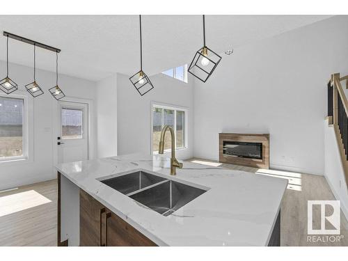 81 Silverstone Drive, Stony Plain, AB - Indoor Photo Showing Kitchen With Fireplace With Double Sink