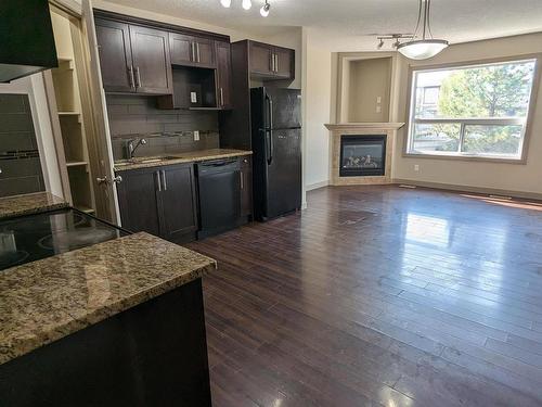 25 1820 34 Avenue, Edmonton, AB - Indoor Photo Showing Kitchen With Fireplace With Double Sink