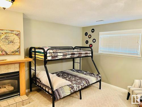 5024 39 Street, Sylvan Lake, AB - Indoor Photo Showing Bedroom With Fireplace