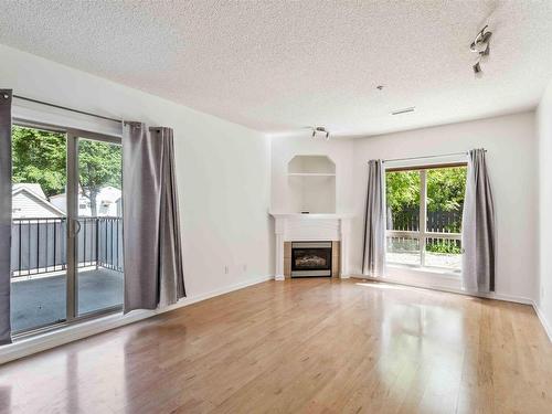 102 10630 78 Avenue, Edmonton, AB - Indoor Photo Showing Living Room With Fireplace