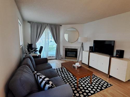 103 10810 86 Avenue, Edmonton, AB - Indoor Photo Showing Living Room With Fireplace