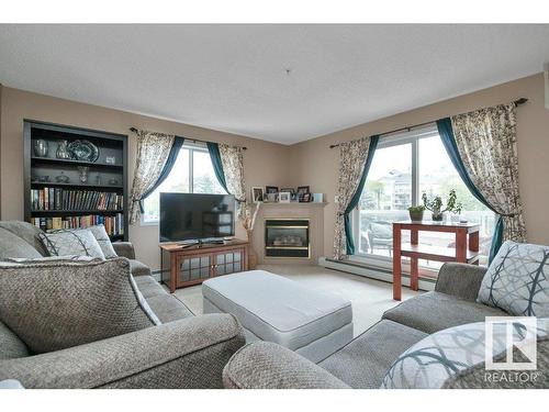 215 17459 98A Avenue, Edmonton, AB - Indoor Photo Showing Living Room With Fireplace