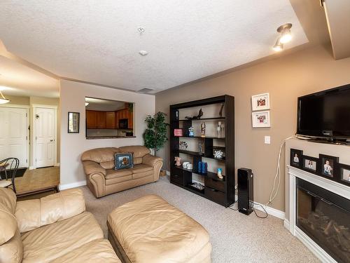 326 7801 Golf Course Road, Stony Plain, AB - Indoor Photo Showing Living Room With Fireplace