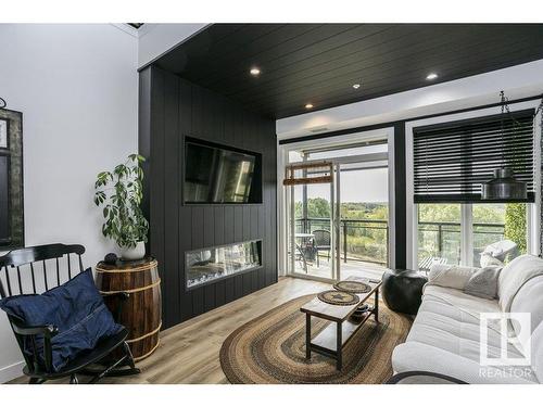 404 9940 Sherridon Drive, Fort Saskatchewan, AB - Indoor Photo Showing Living Room With Fireplace