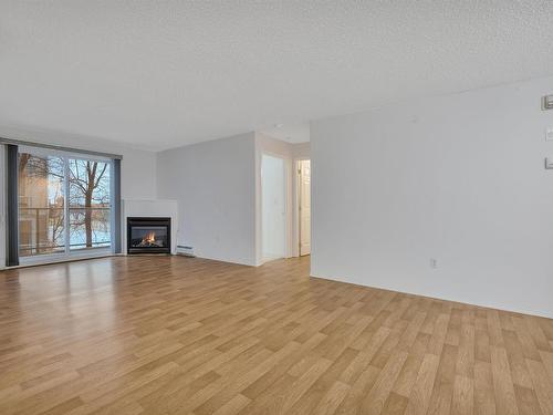 204 5106 49 Avenue, Leduc, AB - Indoor Photo Showing Living Room With Fireplace