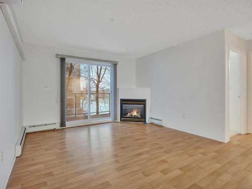 204 5106 49 Avenue, Leduc, AB - Indoor Photo Showing Living Room With Fireplace