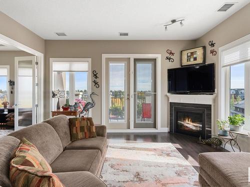 458 6079 Maynard Way, Edmonton, AB - Indoor Photo Showing Living Room With Fireplace