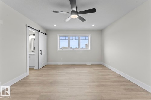 This room features light-colored flooring, a window providing natural light, and a ceiling fan with integrated lighting - 807 Schooner Drive, Cold Lake, AB - Indoor Photo Showing Other Room