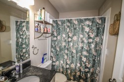 Bathroom with vanity and curtained shower - 