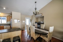 Dining room with dark wood-style flooring, vaulted ceiling, and a chandelier - 