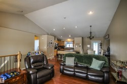 Living area featuring vaulted ceiling, dark wood-style floors, a chandelier, and recessed lighting - 