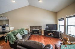 Living area with lofted ceiling, wood finished floors, and a fireplace - 