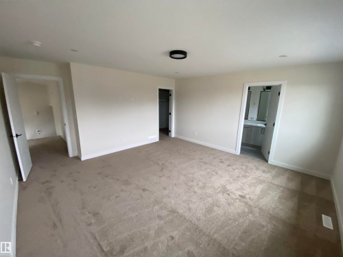 Unfurnished bedroom with carpet, a walk in closet, and ensuite bathroom - 5417 60 Avenue, Vegreville, AB - Indoor Photo Showing Other Room