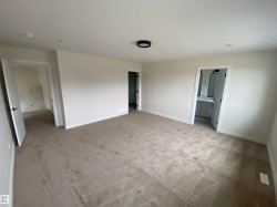 Unfurnished bedroom with carpet, a walk in closet, and ensuite bathroom - 