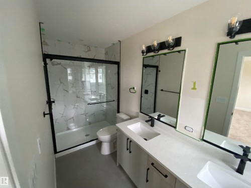 Bathroom featuring double vanity, a marble finish shower, and concrete flooring - 5417 60 Avenue, Vegreville, AB - Indoor Photo Showing Bathroom