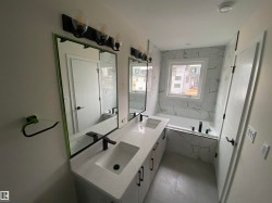 Full bath featuring double vanity and a bath - 
