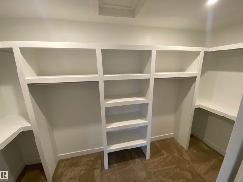 Walk in closet with dark colored carpet - 5417 60 Avenue, Vegreville, AB - Indoor With Storage
