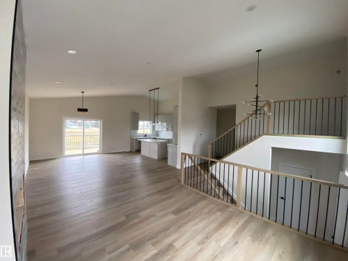 Unfurnished living room featuring light wood-style floors, a chandelier, lofted ceiling, and recessed lighting - 5417 60 Avenue, Vegreville, AB - Indoor