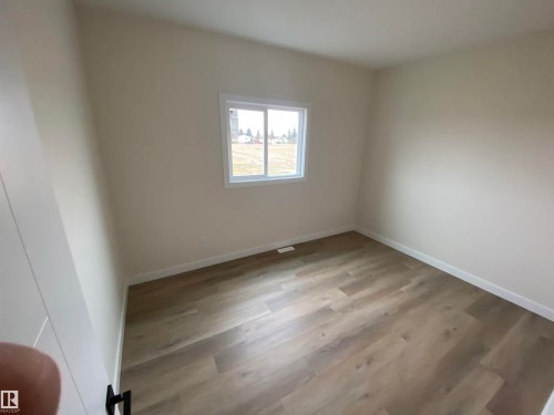 Empty room with light wood-style floors and baseboards - 5417 60 Avenue, Vegreville, AB - Indoor Photo Showing Other Room