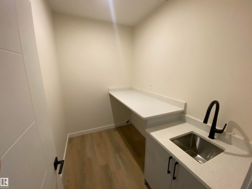 Laundry area with dark wood finished floors and a sink - 5417 60 Avenue, Vegreville, AB - Indoor