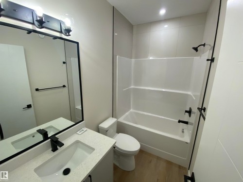 Bathroom with light wood-style floors, vanity, and shower / bath combination - 5417 60 Avenue, Vegreville, AB - Indoor Photo Showing Bathroom