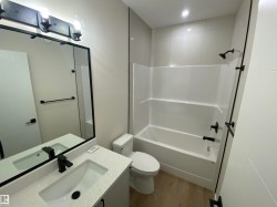 Bathroom with light wood-style floors, vanity, and shower / bath combination - 